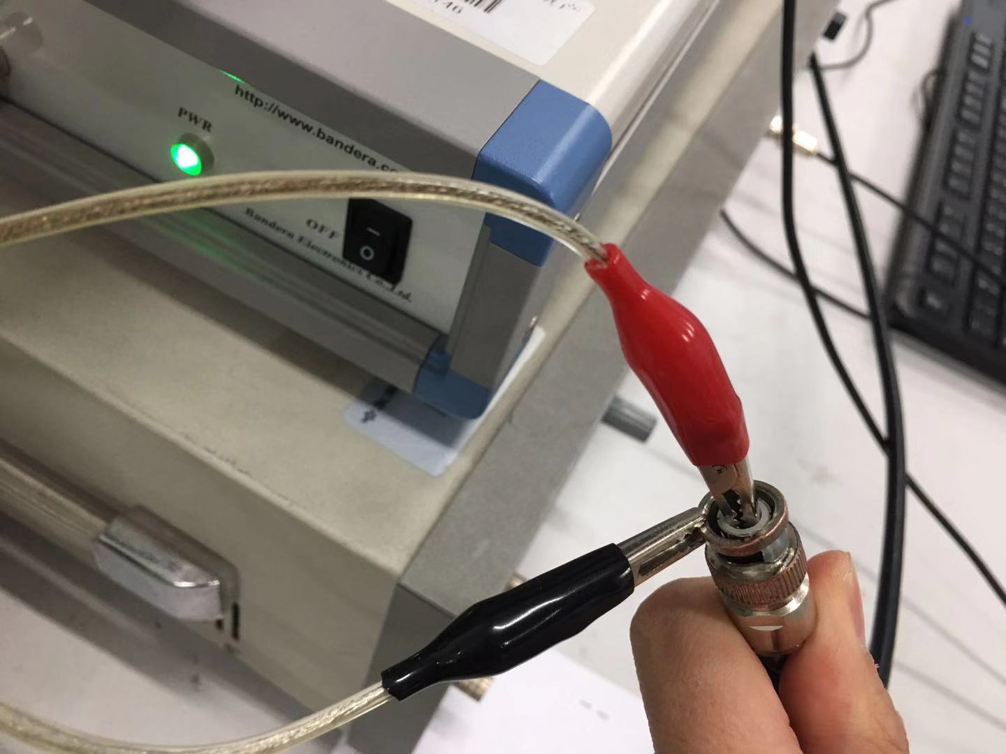 Impedance analyzer connected to the device under test via alligator clips and a BNC connector